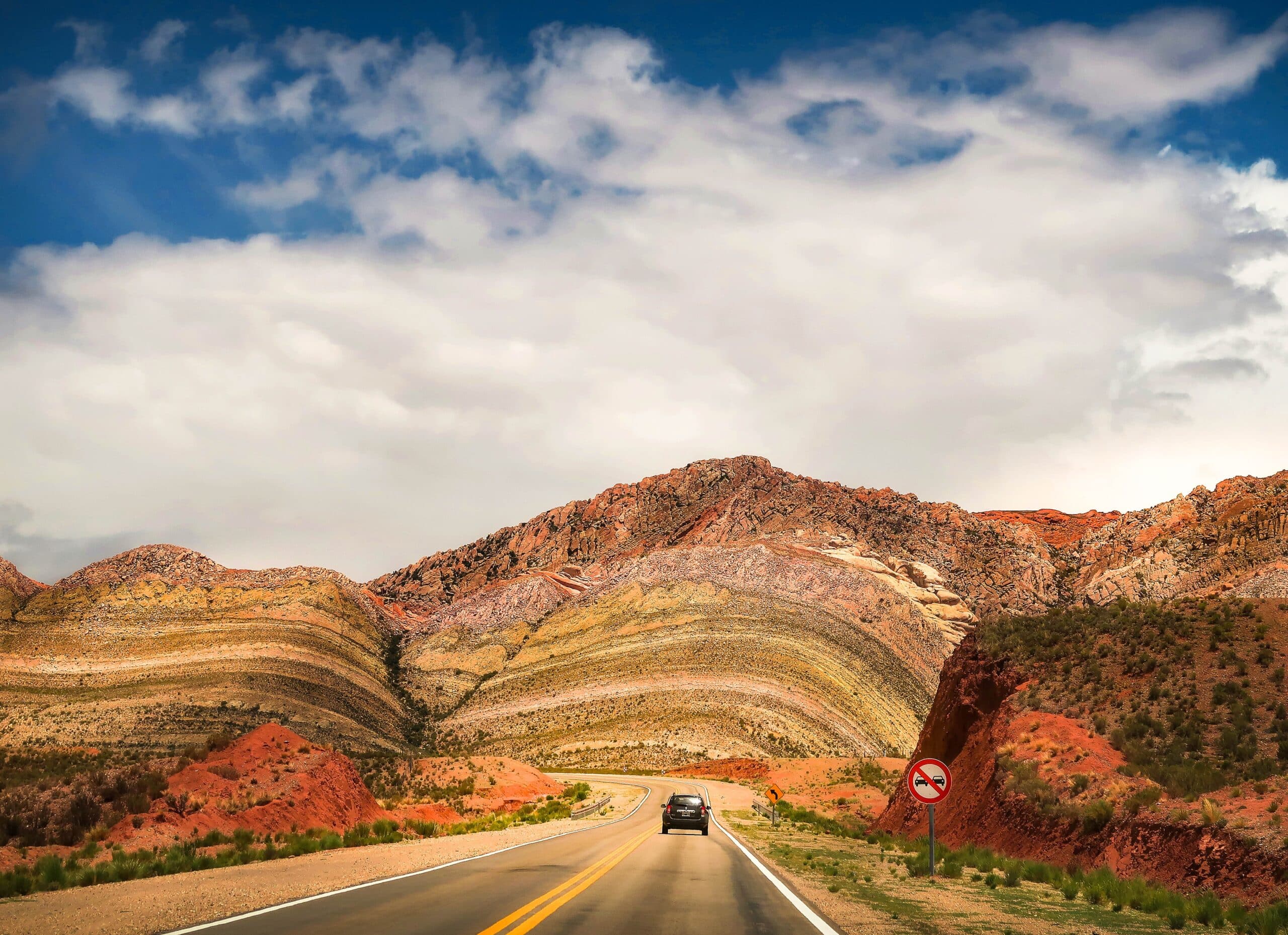 Montañas coloridas del Norte Argentino con un vehículo en la ruta